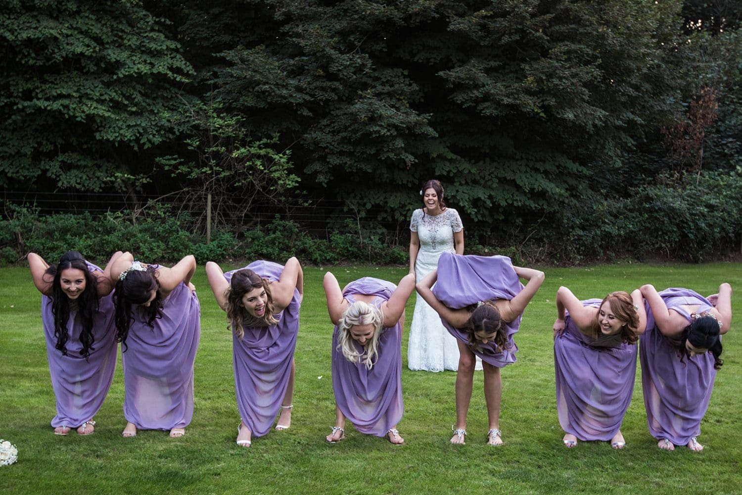 bridesmaids surprise their bride at a suffolk wedding by bending over and showing their bums. The bride laughs!