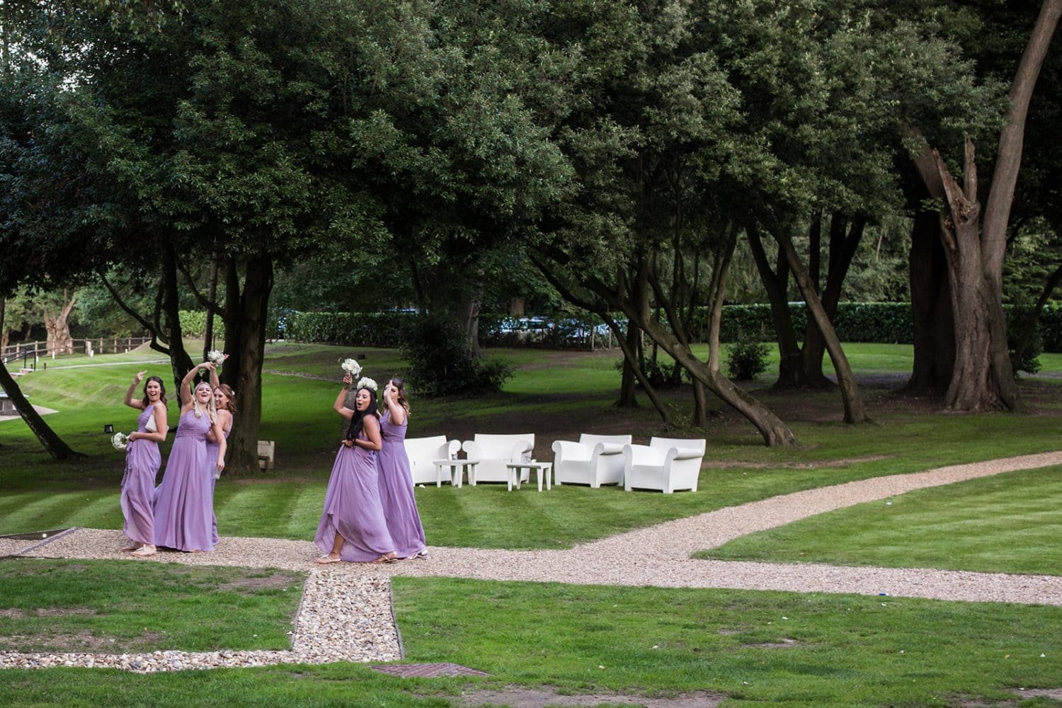 bridesmaids flip the bird as they walk past groomsmen at a suffolk wedding venue