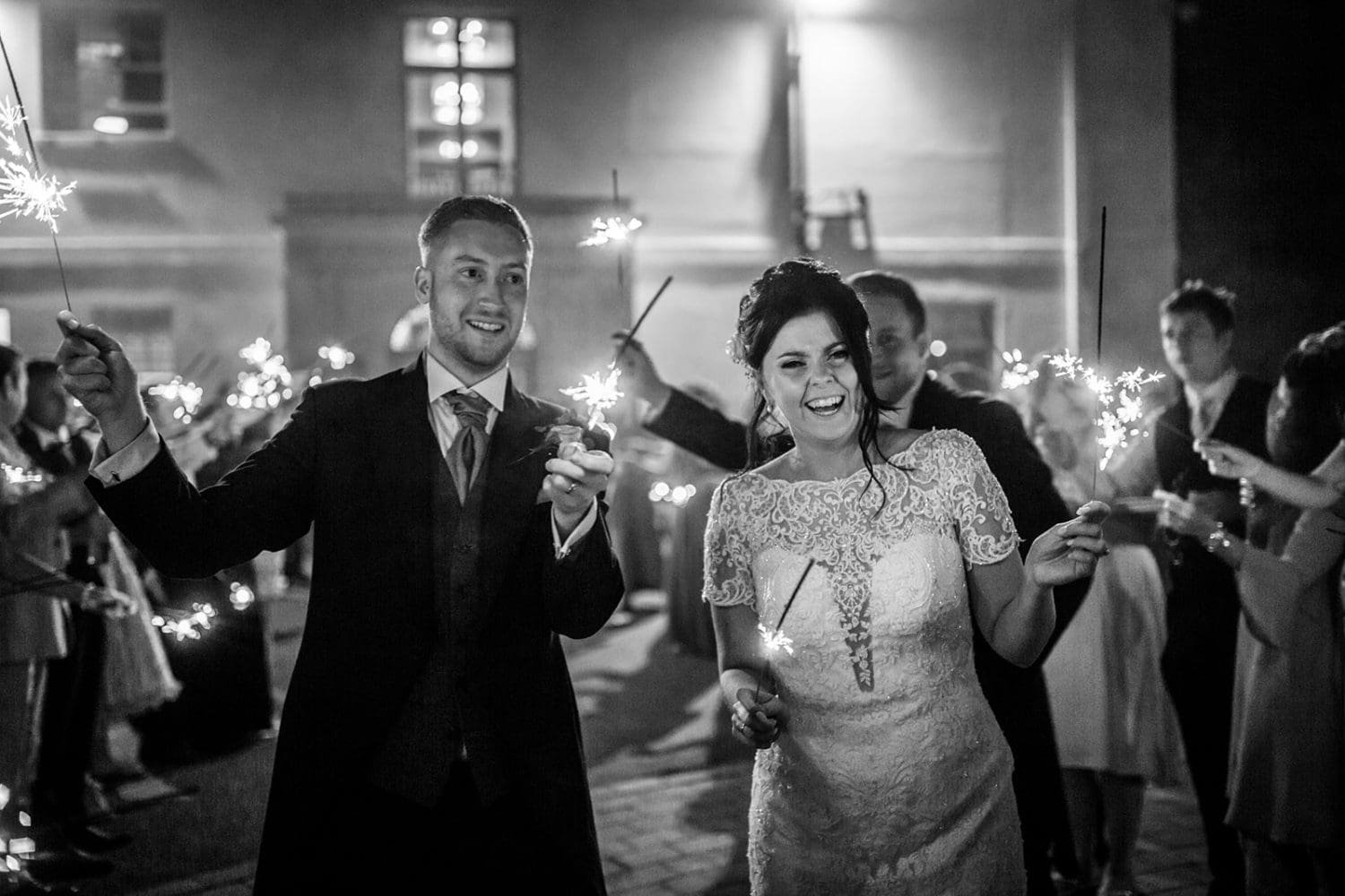 couple enjoy sparklers with their guests at kesgrave hall wedding in suffolk. Milsoms Kesgrave Hall wedding