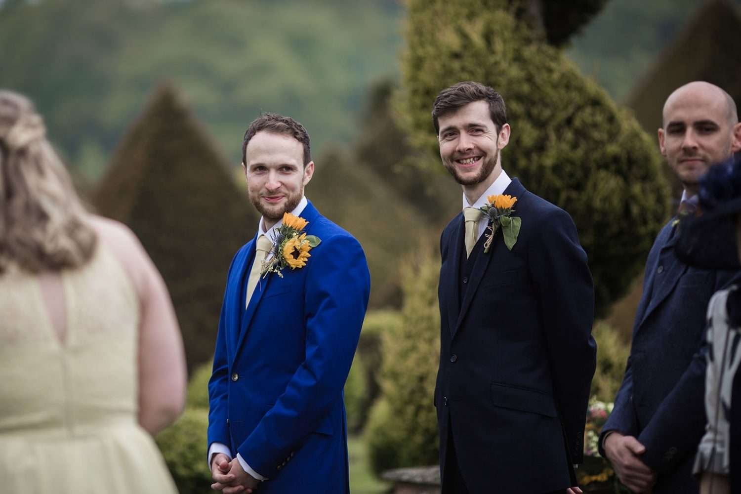 Groom and his best man turn to look as the bride comes down the aisle at her chaucer barn wedding. 

