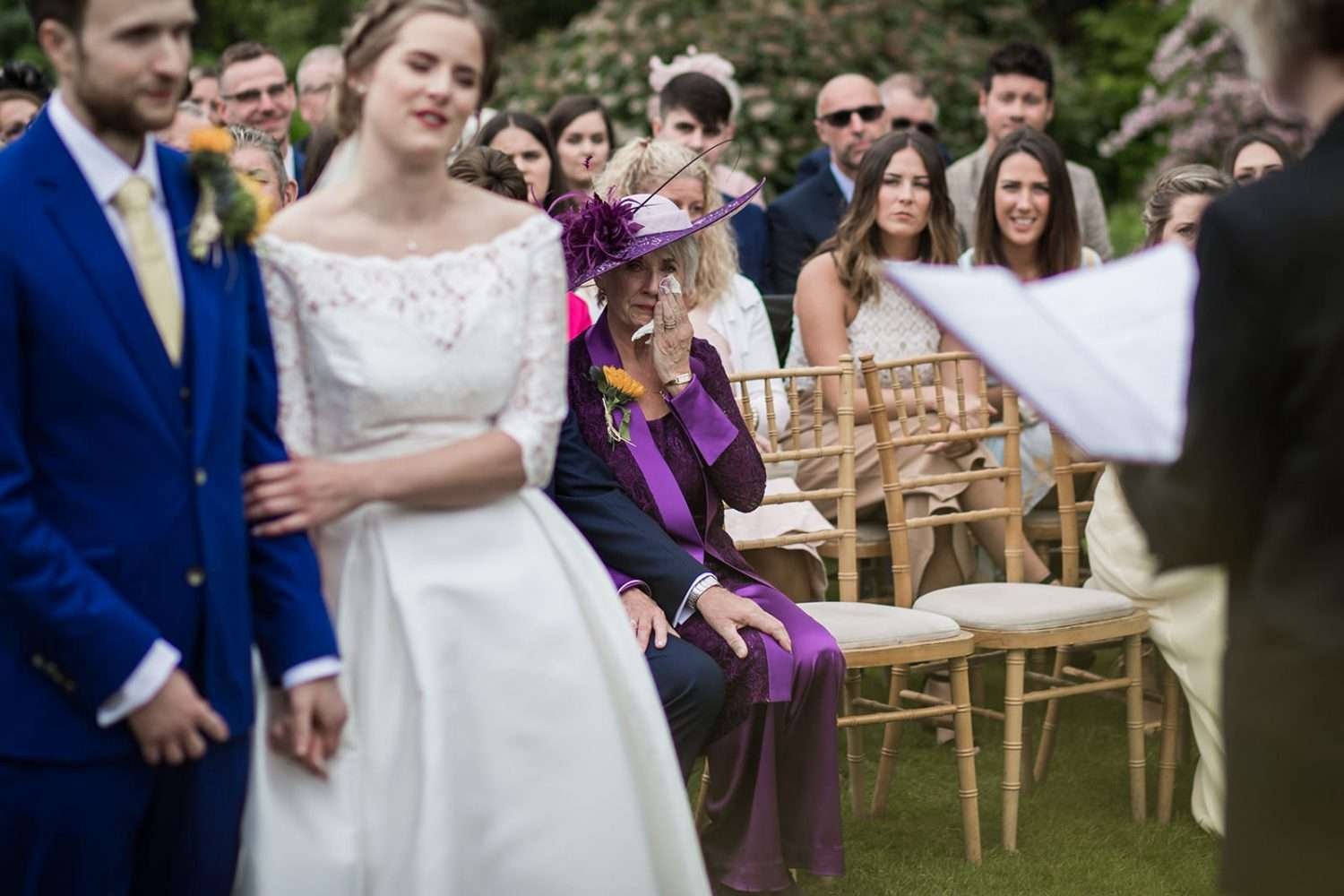 the brides mum has a little cry whilst her daughter gets married in an outdoor ceremony