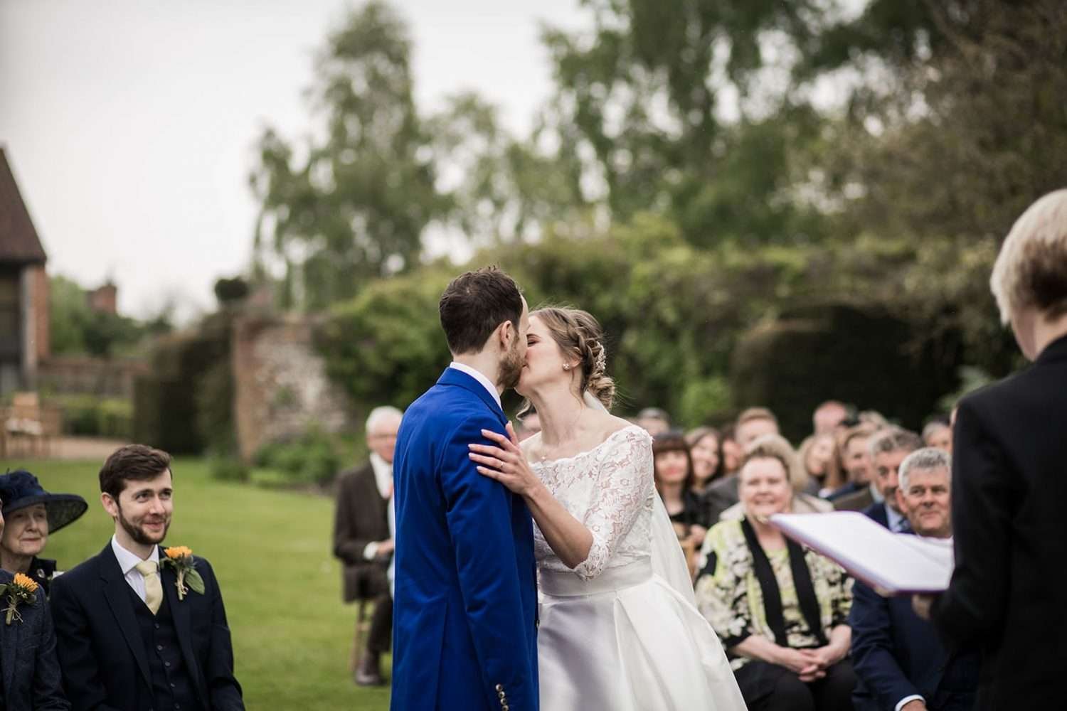 bride and groom have their first kiss during their outdoor norfolk wedding ceremony