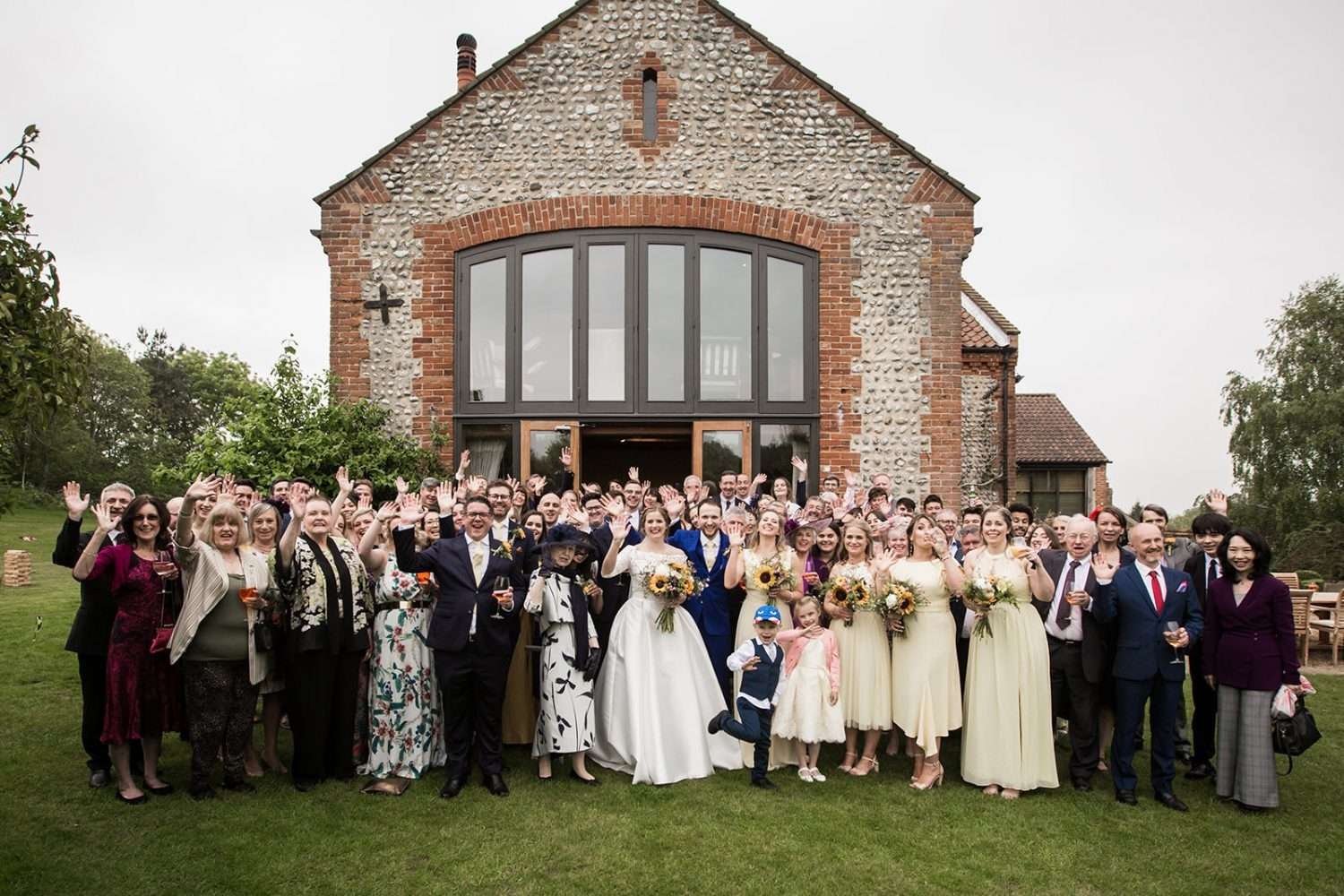 A bride and groom with all their family and their guests for an informal 'formal' wedding photo.
