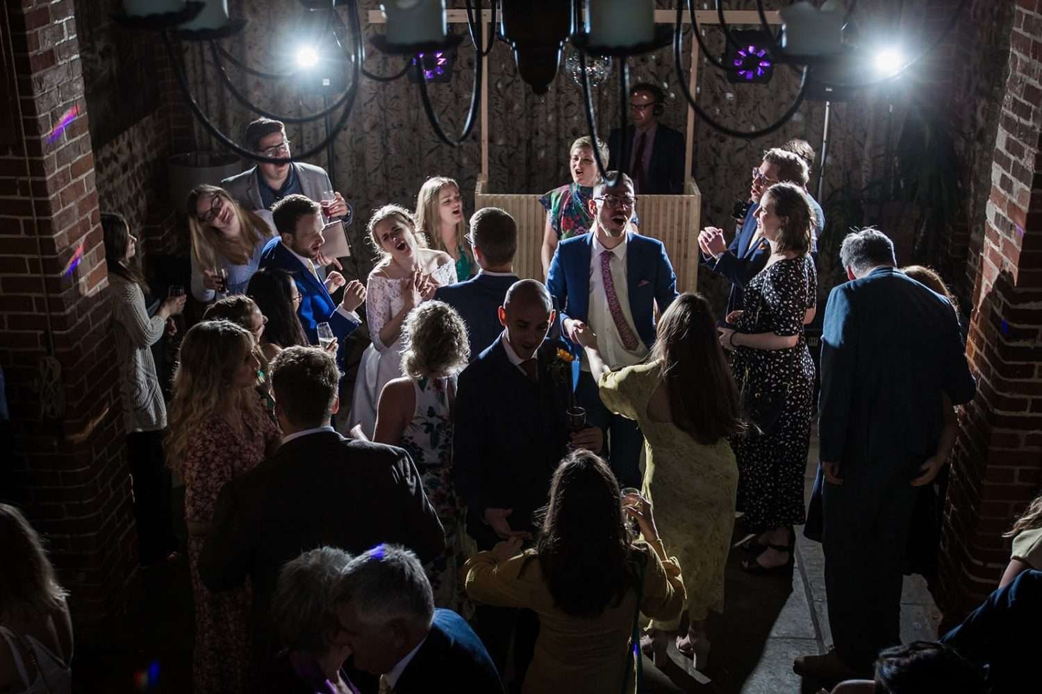 guests and couple dance and sing at a wedding in a barn in norfolk