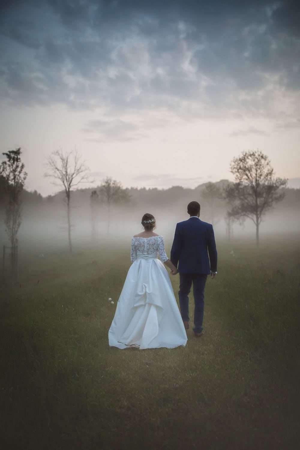 late evening couple portrait at a wedding, mist is beginning to envelop the meadows at a chaucer barn wedding in Norfolk . 