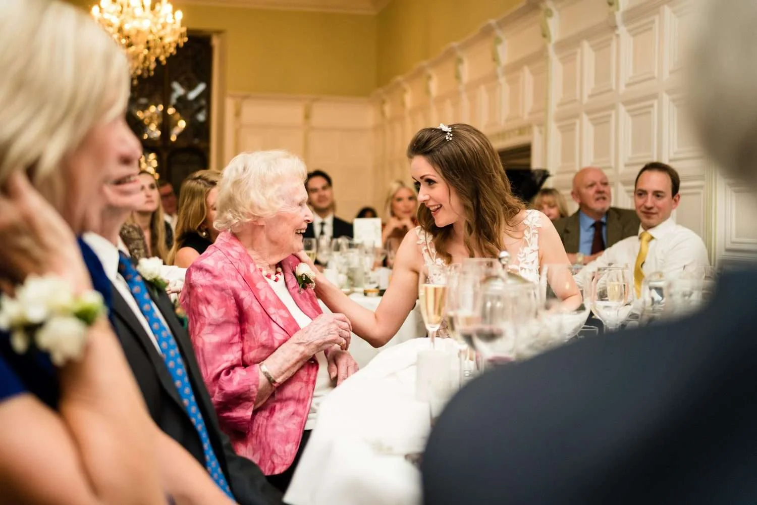 grandma laughs with her granddaughter during the granddaughters wedding breakfast