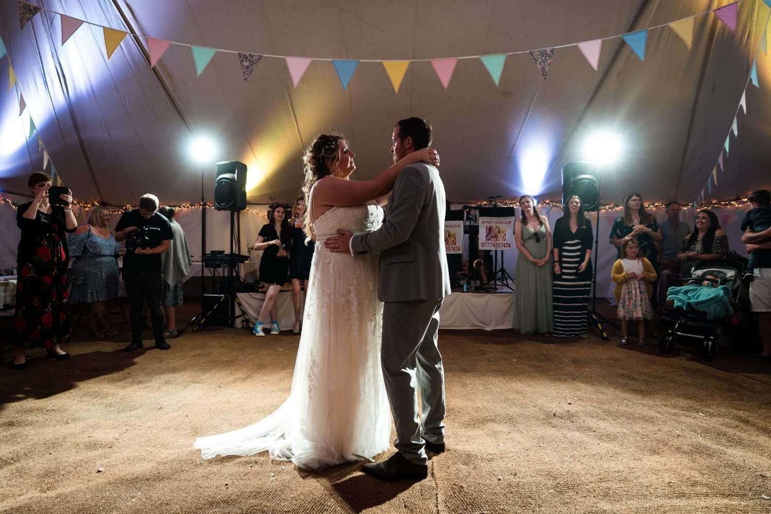 bride and groom laugh during an active first dance at their village hall wedding in Suffolk