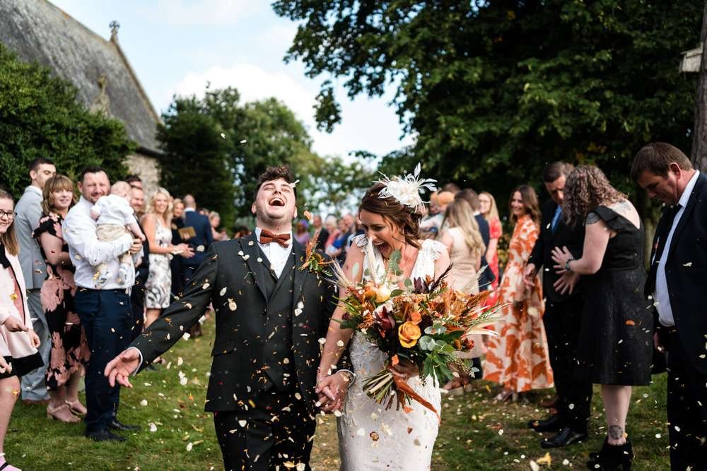 Couple enjoying confetti at their Fishley Hall wedding 