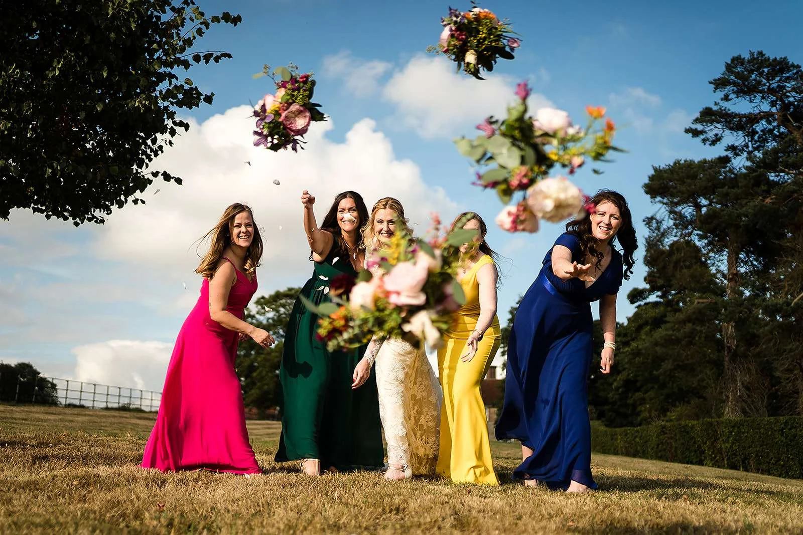 Bridal party hurl bouquets at Neil from Lisa and Neil wedding photography at a Bruisyard Hall wedding