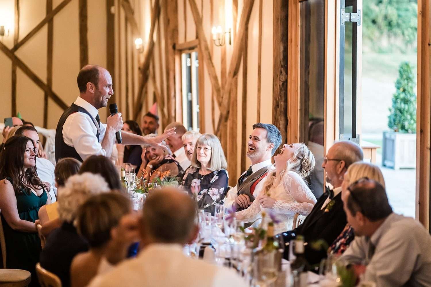 Dinner and speeches in beautiful golden light at a Bruisyard hall wedding