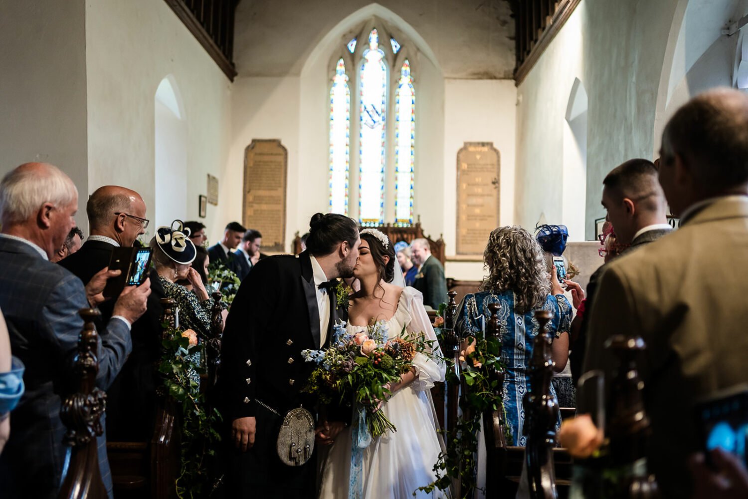 the couple kiss as they are walking out of their  fishley church wedding ceremony 