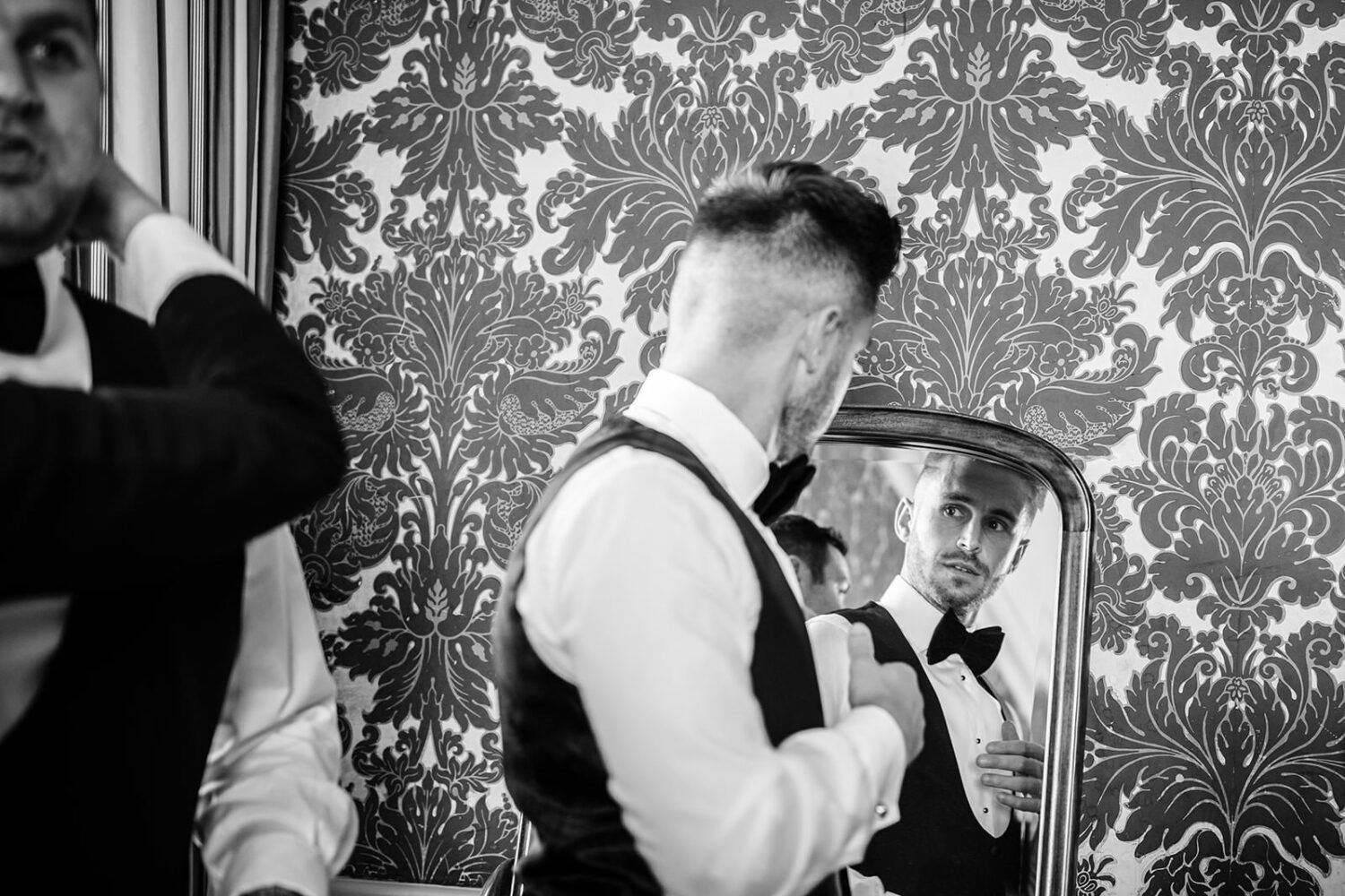 Groom getting ready in the mirror at hengrave hall 