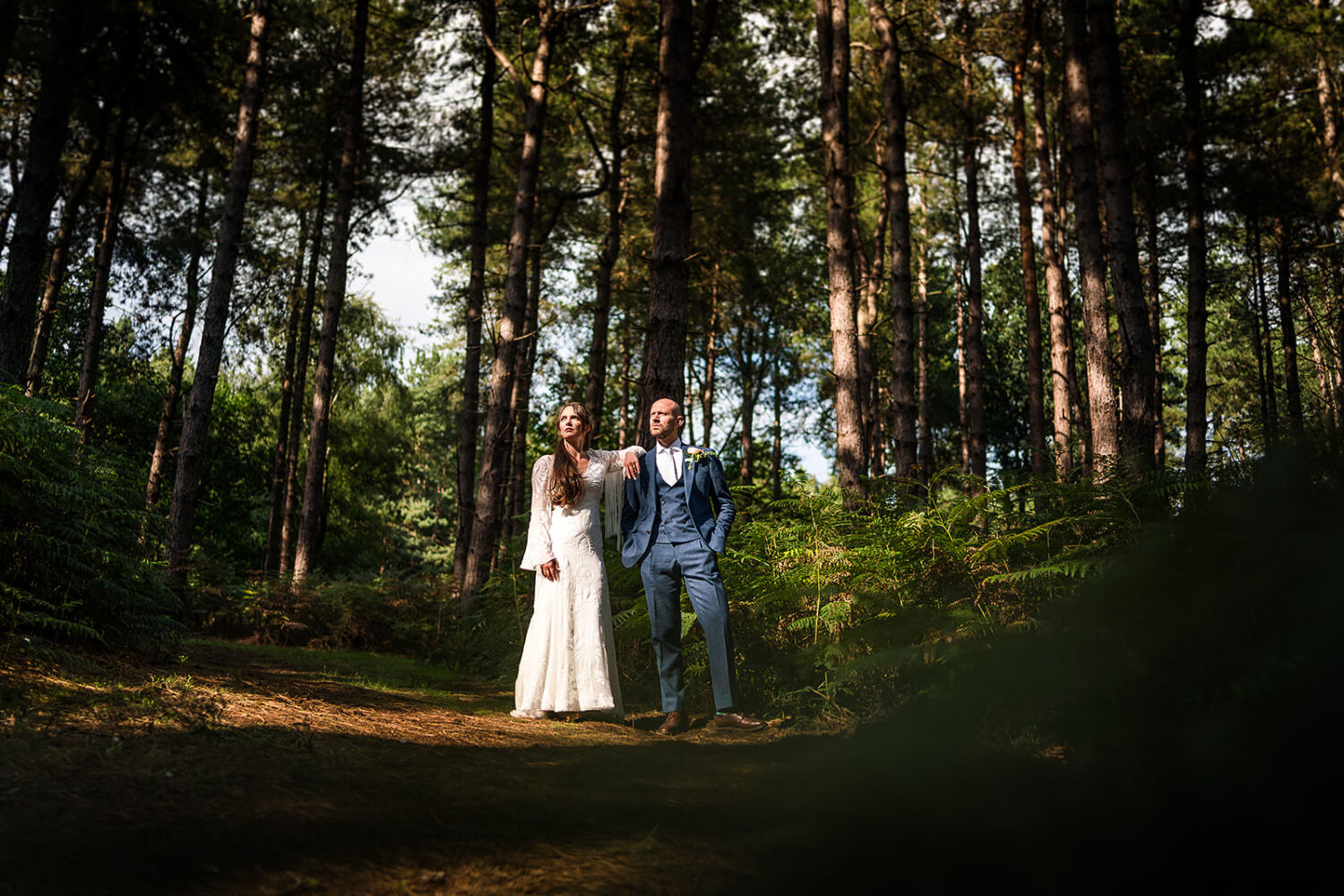 wedding couple pose for portraits in the woods at happy valley grimston