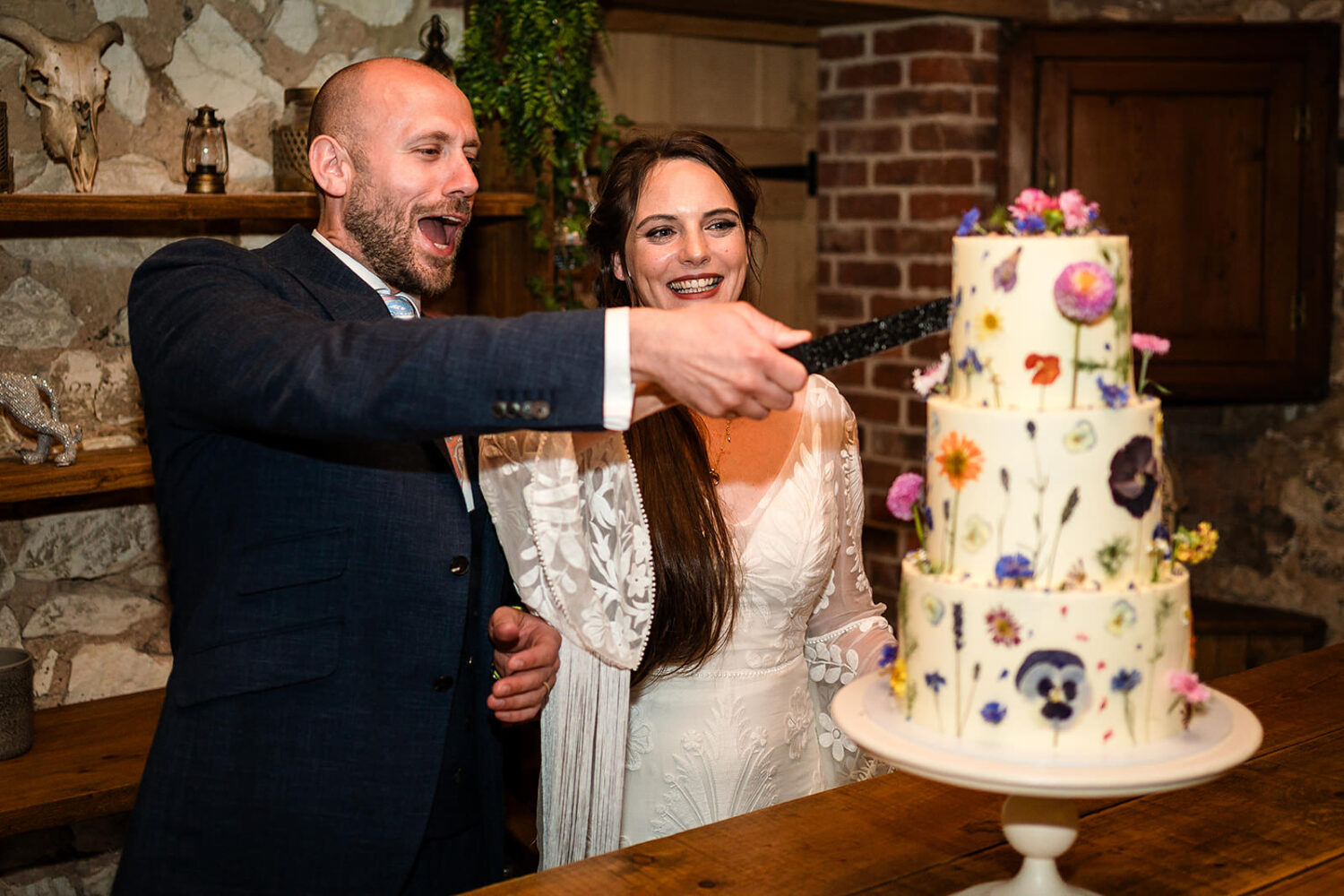 couple cutting their wedding cake at happy valley in the hay barn
